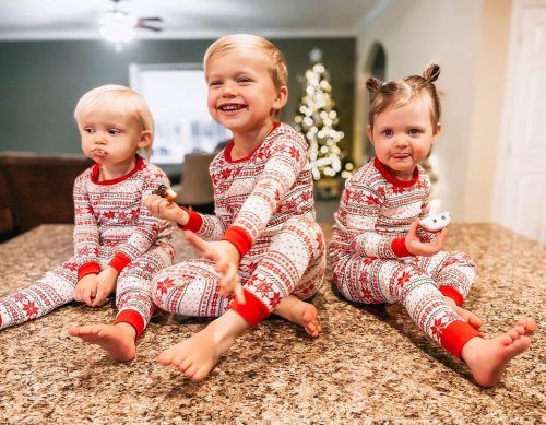 Three kids in Christmas pyjamas.