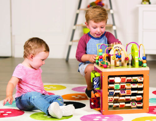 Two kids playing with an activity cube.