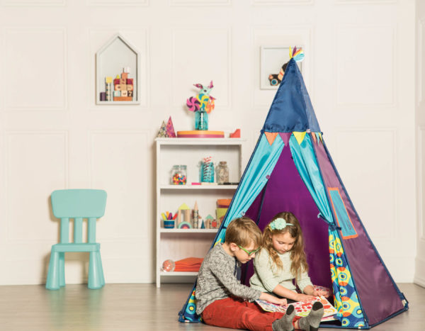 A boy and a girl in an indoor tent.