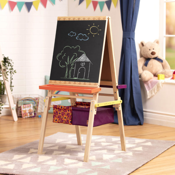 Kids easel with a drawing of a house with trees and sky on it.