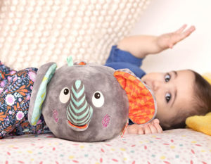 Baby with plush elephant toy.