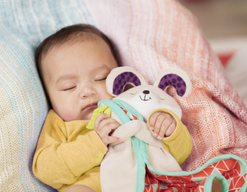 Sleeping baby cuddling a bunny-shaped security blanket.