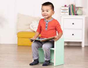 Toddler sitting on step stool.