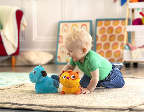 Baby playing with a plush dog and cat.