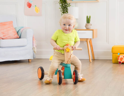 B. toys_Smooth Rider Boy on a toddler bike in a room.