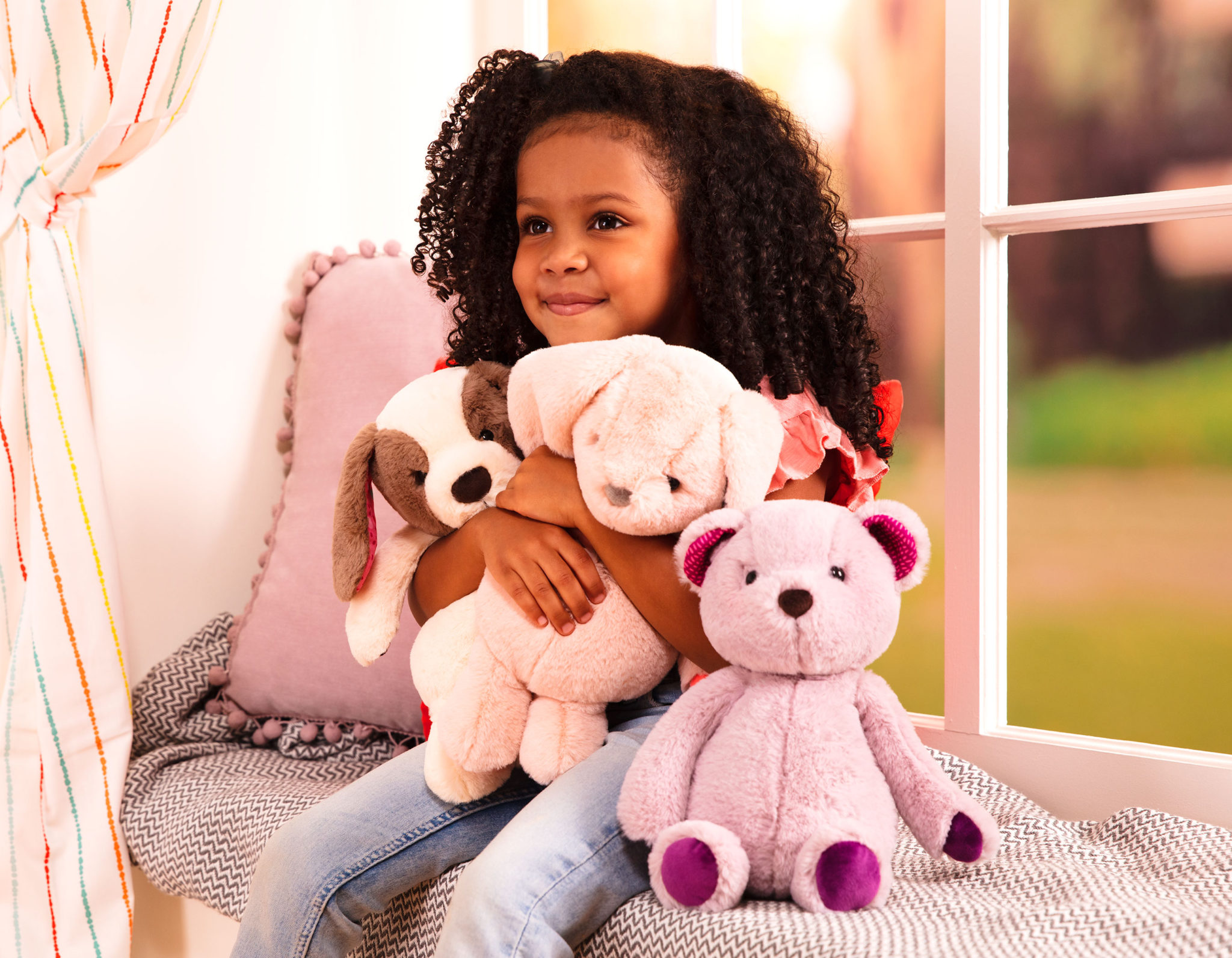 Girl and three stuffed animal toys.