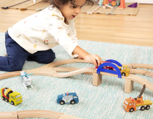 Girl playing with wooden cars.