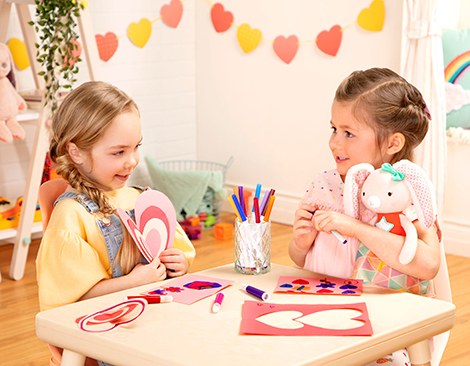 Two girls doing Valentine's Day crafts.